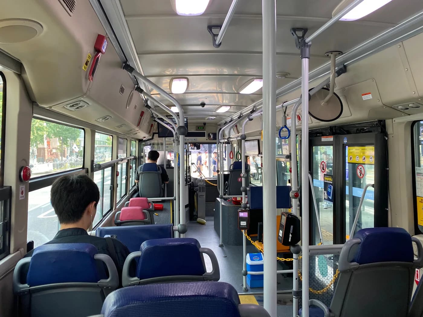 Seoul bus interior with red stop buttons and a card reader beside the exit door