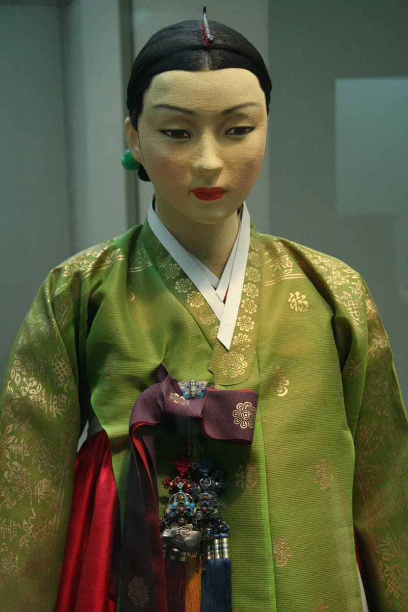 Museum mannequin in a green Korean hanbok with a tasselled norigae hanging at the front of the garment.