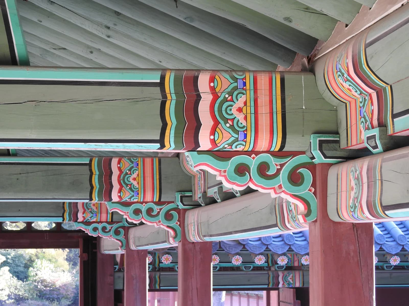 Painted green and red wooden beams with floral and striped dancheong details at Changgyeonggung in 2023