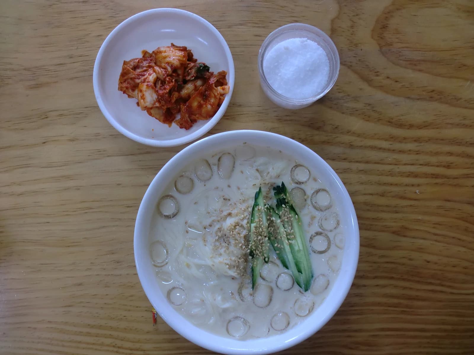 Kongguksu in white soybean broth with cucumber, sesame and ice.